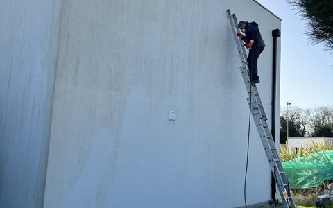 Traitement d’une façade encrassée depuis une échelle par l’Entreprise Felicioni