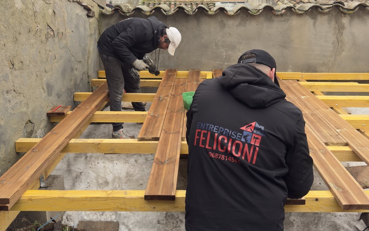 Deux compagnons de l’Entreprise Felicioni vissent les lames d’une terrasse en bois sur des lambourdes