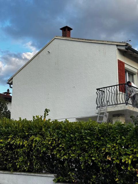 Façade de maison ravalée, enduit blanc et parement brique
